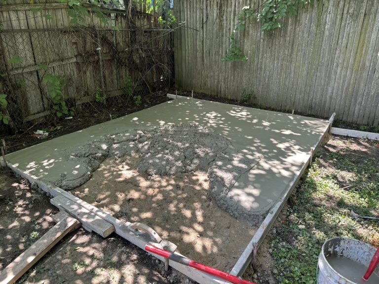 Fresh concrete being placed and leveled during residential patio installation project.